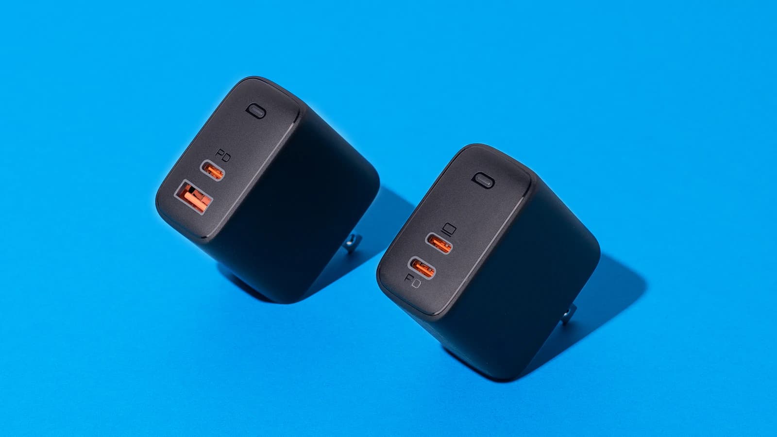 Dos cargadores de pared con puertos USB sobre fondo azul