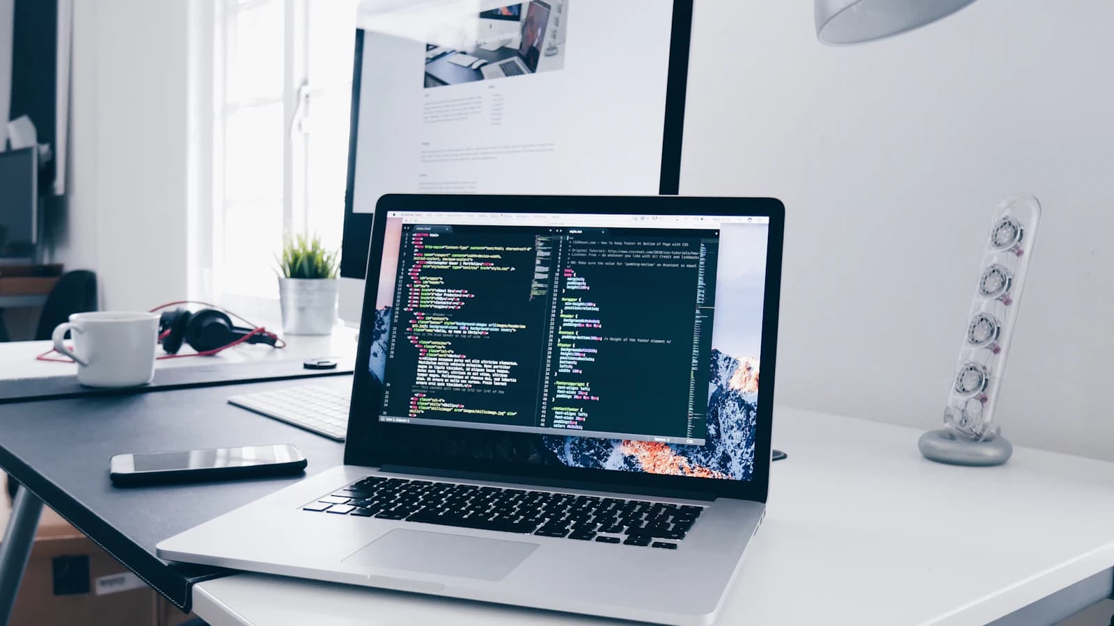 Escritorio de trabajo con laptop abierta junto a una ventana