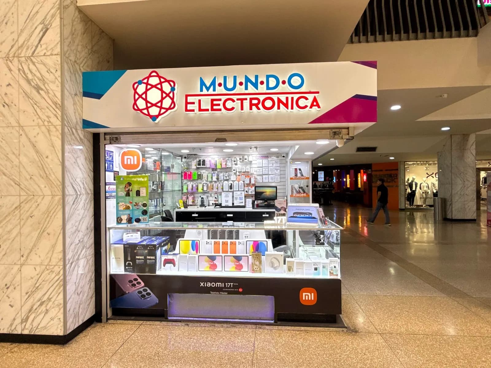 Kiosco de Mundo Electrónica en la planta baja del CCCT, frente a las escaleras mecánicas, con vitrinas de smartphones y consolas