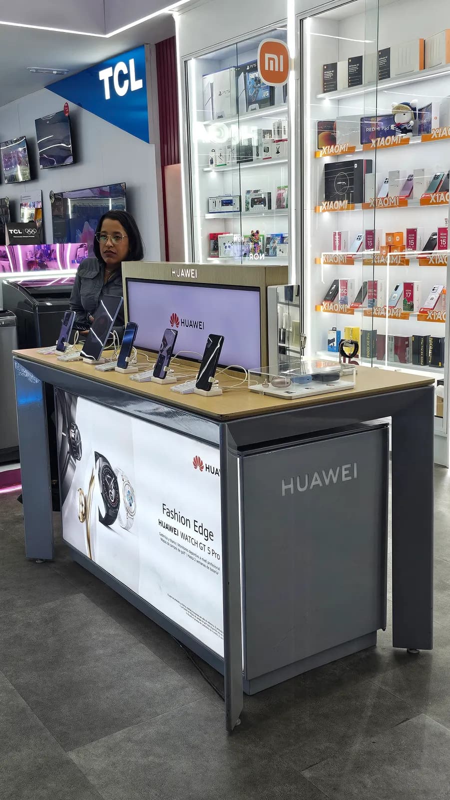 Asesora mostrando un equipo en la mesa de experiencia Huawei de la tienda